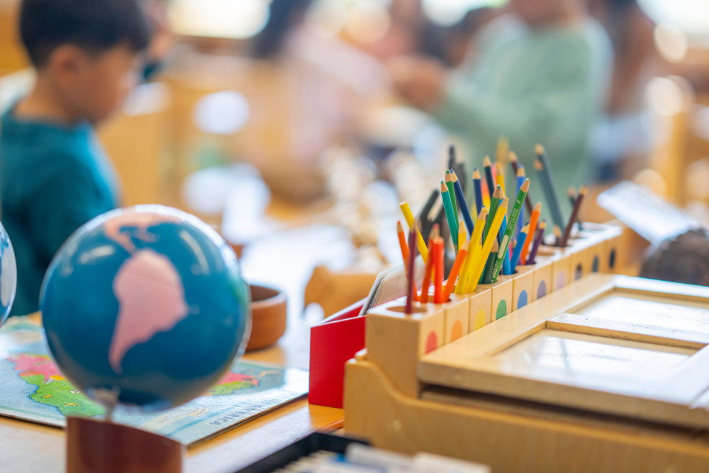 Image of children in a classroom raising their hands