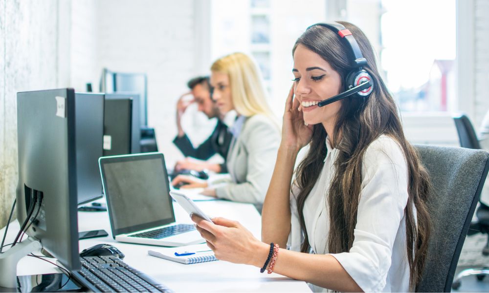 Lady sat at a desk using an IP phone